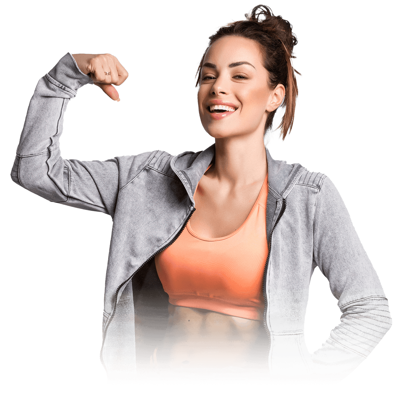 A woman in an orange top and gray sweatshirt, smiling while flexing her bicep.