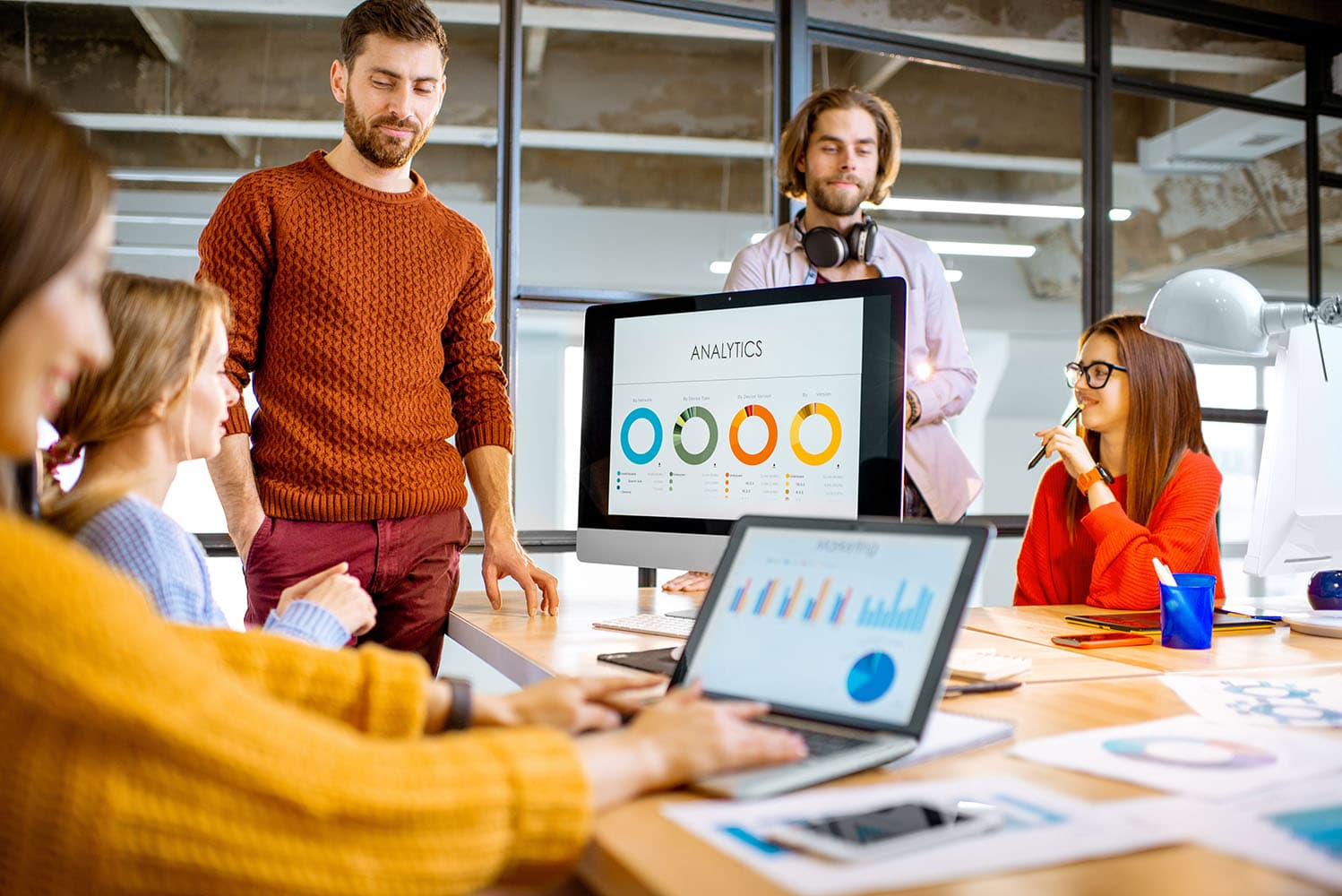 A room with people working and discussing, showcasing Daxko's nonprofit-focused digital marketing team dedicated to your mission.